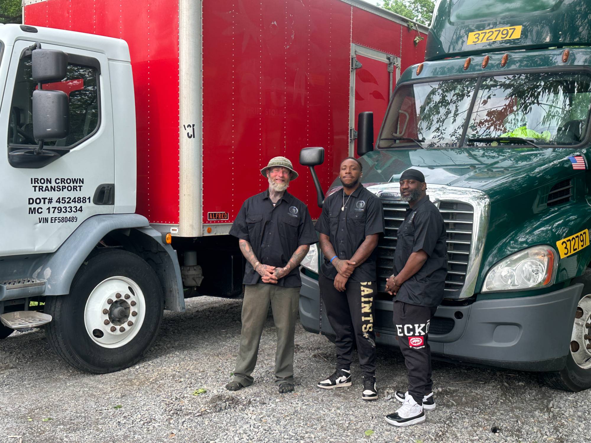 The Iron Crown Transport team standing in front of company trucks